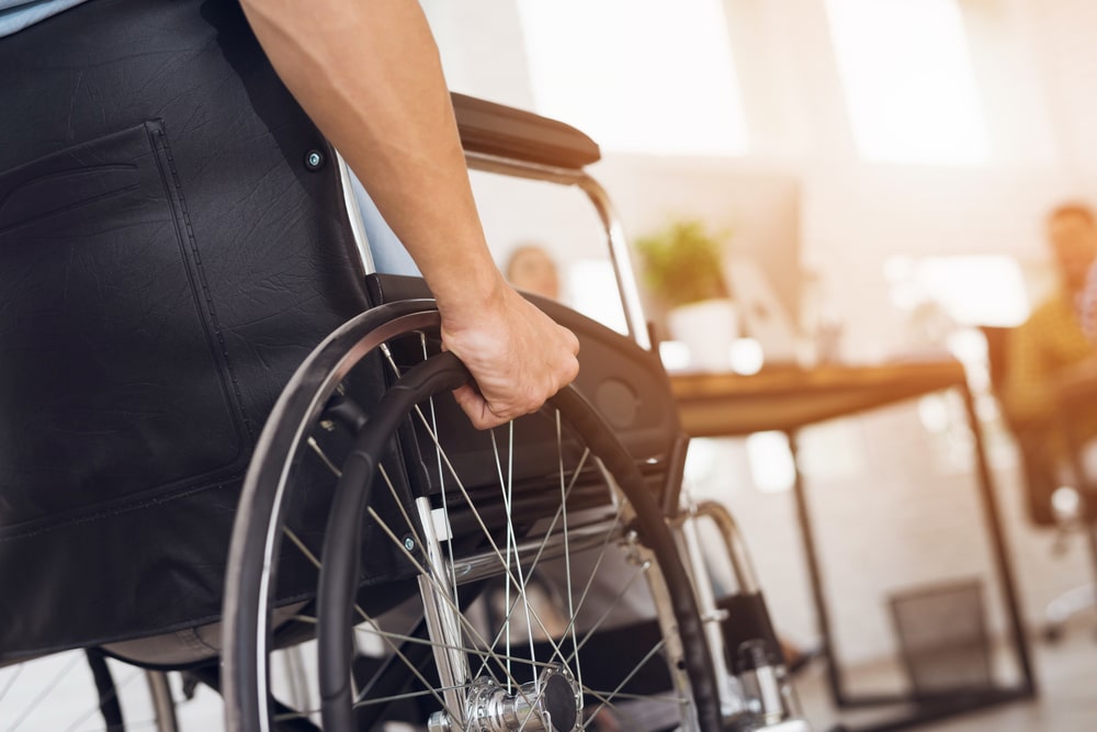 A cropped shot of a person with ALS in a wheelchair